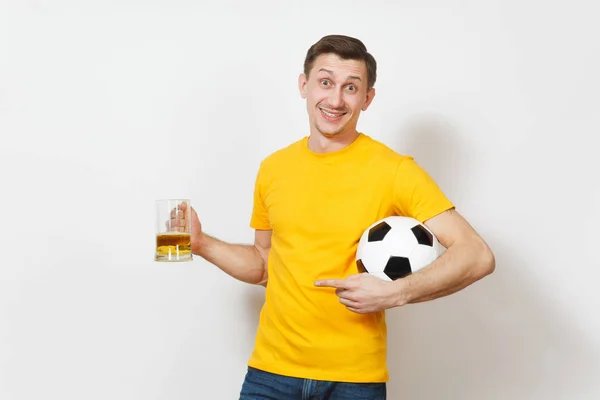 Inspirado joven divertido alegre hombre europeo, ventilador o jugador en uniforme amarillo sostener jarra de cerveza, pelota de fútbol animar equipo de fútbol favorito aislado sobre fondo blanco. Deporte, juego, estilo de vida concepto . — Foto de Stock