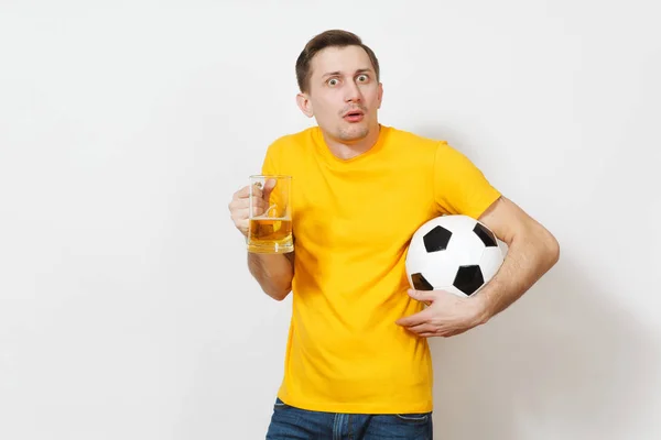 Triste sconvolto giovane uomo europeo disorientato, tifoso o giocatore in uniforme gialla tenere pinta tazza di birra, squadra di calcio preferito tifo palla isolato su sfondo bianco. Sport, gioco, lifestyle concept . — Foto Stock