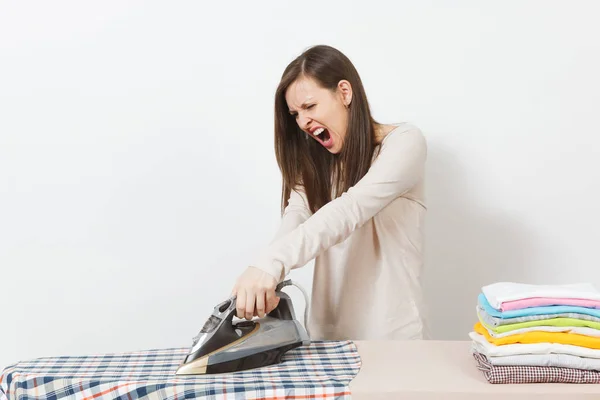 Arga aggressiva skrikande hemmafru i lätta kläder strykning hu — Stockfoto