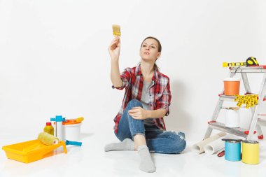 Rahat kıyafetler yenileme daire oda beyaz arka plan üzerinde izole için aygıtlar fırça, katta oturan güzel kadın. Boyama araçları yapıştırma için aksesuarları duvar kağıdı. Onarım ev concept