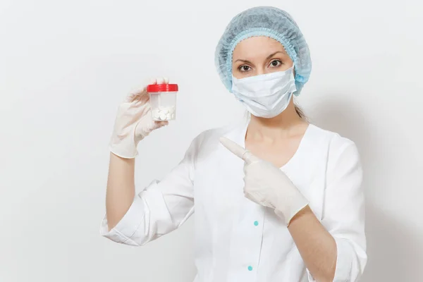 Giovane dottoressa con maschera viso, cappello sterile, guanti isolati su sfondo bianco. Medico chirurgo donna in abito medico bottiglia di tenuta con pillole. Personale sanitario, salute, concetto di medicina . — Foto Stock