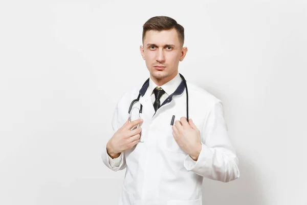 Poważny pewnie doświadczony młody przystojny lekarz mężczyzna na białym tle. Lekarz mężczyzna w mundurze medycznych, przytrzymanie stetoskop wyglądający aparat. Pracowników służby zdrowia, zdrowia, medycyny pojęcie — Zdjęcie stockowe