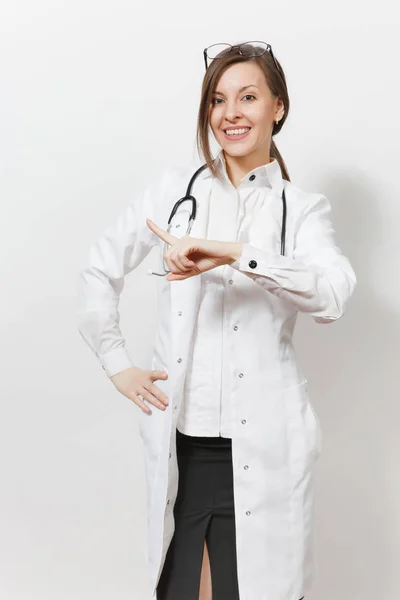Mujer joven y sonriente con estetoscopio, gafas aisladas sobre fondo blanco. Doctora en bata médica señalando el dedo índice a un lado en el espacio de copia. Concepto de medicina sanitaria del personal sanitario — Foto de Stock