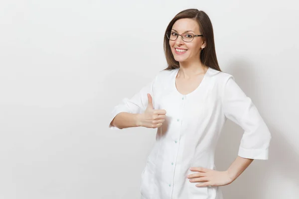 Χαμογελαστός νεαρός γιατρός γυναίκα με γυαλιά που απομονώνονται σε λευκό φόντο. Γυναίκα γιατρό σε ιατρική φόρεμα δείχνει thumbs up, αντίγραφο χώρος για διαφήμιση. Νοσηλευτικού προσωπικού, την υγεία, την ιατρική έννοια. — Φωτογραφία Αρχείου