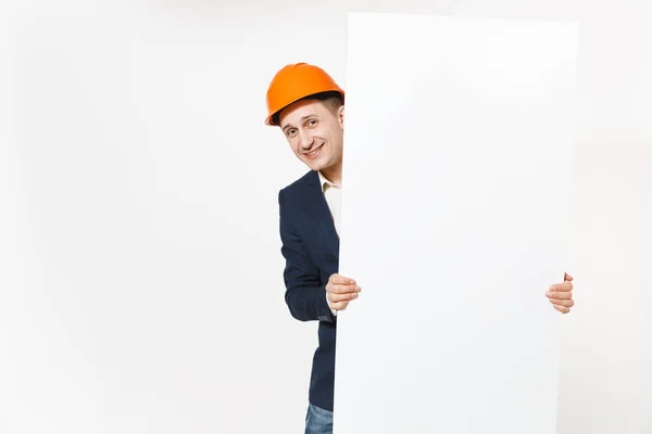 年轻的微笑商人在深色西装, 保护安全帽持有大白色空空白材料与复制空间, 地方为文本或图像隔离在白色背景。广告男工作者. — 图库照片