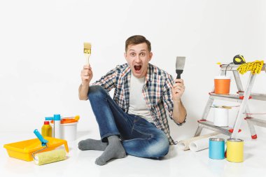 Beyaz arka plan üzerinde izole yenileme daire oda için fırça, macun bıçak aygıtlar ile katta oturan deli adam çığlık. , Duvar kağıdı yapıştırma aksesuarları, boyama araçlarını. Onarım ev concept.