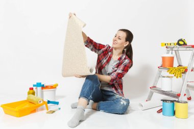 Rahat kıyafetler beyaz arka plan üzerinde izole yenileme daire için duvar kağıdı aygıtlar gelişeceğini rulo ile katta oturan kadın. Araçlar yapıştırma için aksesuarlar. Onarım ev kavramı kopya alanı