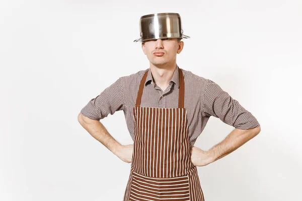 Διασκέδαση άνθρωπος σε ριγέ ποδιά με ασημί ανοξείδωτο γυαλιστερό αλουμίνιο άδειο stewpan, τηγάνι ή σε κατσαρόλα στο κεφάλι που απομονώνονται σε λευκό φόντο. Αρσενικό οικονόμος ή houseworker. Μαγειρικά σκεύη, πιάτα, κουζίνα έννοια. — Φωτογραφία Αρχείου