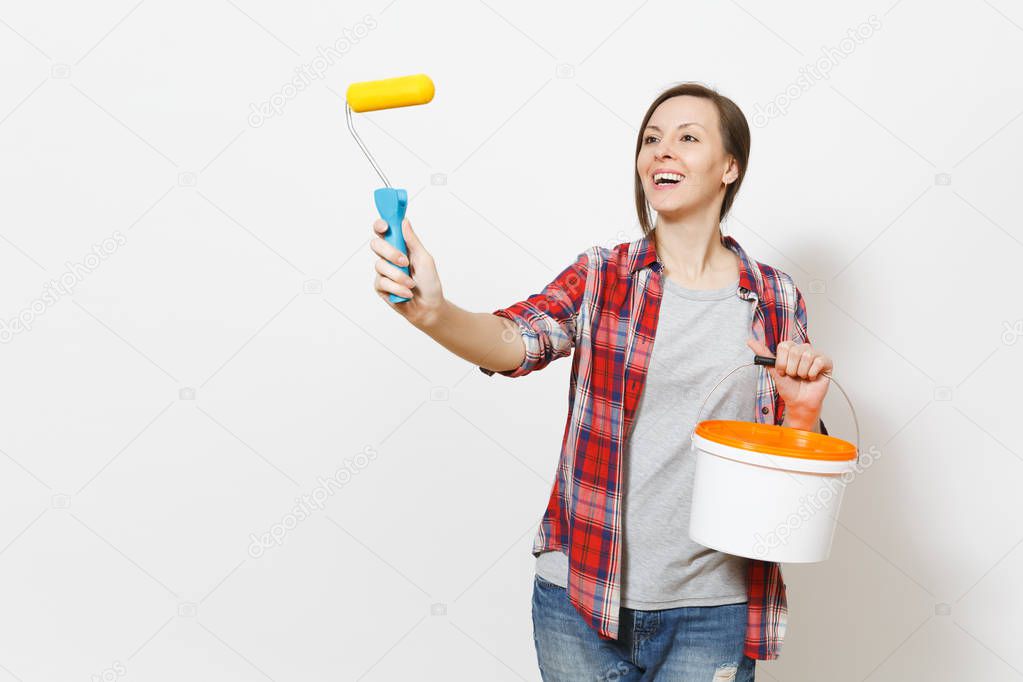 Woman holding empty paint bucket, pointing paint roller for wall painting on copy space isolated on white background. Instruments, accessories, tools for renovation apartment room. Repair home concept