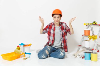 Beyaz arka plan üzerinde izole yenileme daire için aygıtlar ile katta oturan turuncu koruyucu kask içinde eğlenceli deli kadın. Duvar kağıdı, yapıştırma, boyama araçları için aksesuarlar. Onarım kavramı.