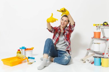 Rahat kıyafetler oturan kat sarı eldivenli, beyaz arka plan üzerinde izole yenileme daire için aygıtlar üzerinde eğlenceli güzel kadın. Boyama araçları için aksesuarlar duvar kağıdı. Onarım ev concept