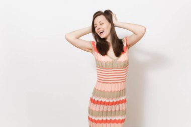 Hafif bej ve pembe desenli elbise gülümseyen içinde güzel genç esmer kız zevk ve Studio beyaz arka plan üzerinde kafa yakınındaki ellerini tutun. İyi bir ruh hali kavramı. Kopya alanı reklam için.