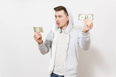 Genç yakışıklı adam öğrenci tişört içinde şok ve bir dolarlık Bono ve sürpriz bakar, onları beyaz arka plan üzerinde izole kulaklık ile hood ile hafif kazak tutar. Duygular kavramı