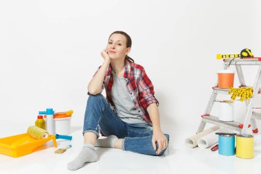 Beyaz arka plan üzerinde izole yenileme daire oda için aygıtlar ile katta oturan rahat kıyafetler içinde güzel bir kadın. Duvar kağıdı, yapıştırma, boyama araçları için aksesuarlar. Onarım ev kavramı.