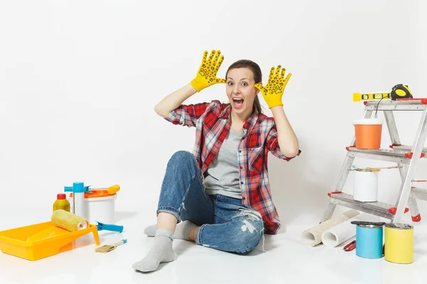 stock image Fun pretty woman in casual clothes sitting on floor with yellow gloves, instruments for renovation apartment isolated on white background. Wallpaper accessories for painting tools. Repair home concept