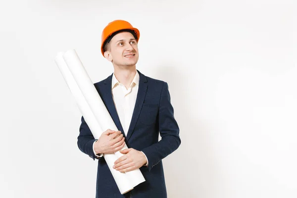 Empresário sorridente em terno escuro, capacete de construção protetora segurando planos de plantas e olhando para cima no espaço de cópia isolado em fundo branco. Trabalhador masculino para propaganda. Conceito de negócio . — Fotografia de Stock