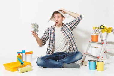 Şok gazetesi şapka erkekte bohça-in dolar, nakit para tutar. Beyaz arka plan üzerinde izole yenileme daire için aygıtlar. , Duvar kağıdı yapıştırma aksesuarları, boyama araçlarını. Onarım ev concept.