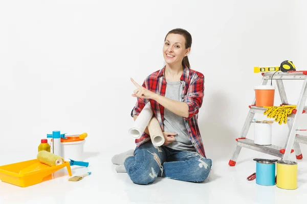 Γυναίκα σε casual ρούχα που κάθεται στο πάτωμα με ταπετσαρία ρολά, όργανα για διαμέρισμα ανακαίνιση που απομονώνονται σε λευκό φόντο. Αξεσουάρ για την κόλληση εργαλεία ζωγραφικής. Επισκευή concept home. Χώρο αντίγραφο — Φωτογραφία Αρχείου