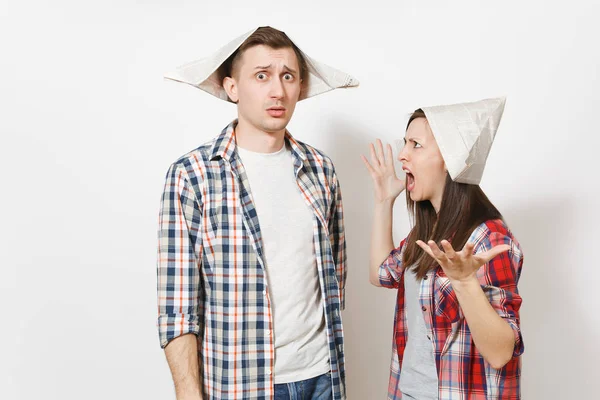 Jeune femme insatisfaite, homme en tenue décontractée et chapeaux de journaux se disputant. Couple isolé sur fond blanc. Instruments, accessoires pour la rénovation appartement chambre. Réparation concept de maison . — Photo