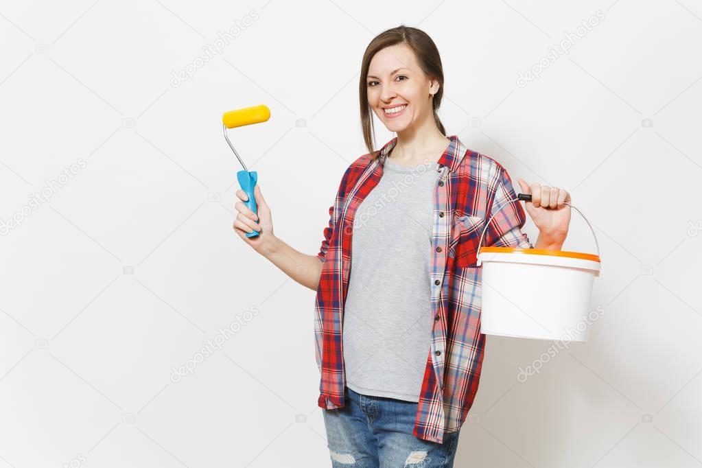 Smiling woman holding paint roller for wall painting and empty bucket with copy space isolated on white background. Instruments, accessories, tools for renovation apartment room. Repair home concept.