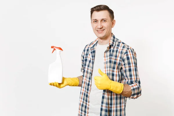 Young housekeeper man in checkered shirt, yellow gloves holding empty cleaning spray bottle with cleaner liquid isolated on white background. Male doing house chores. Copy space for advertisement. — Stock Photo, Image