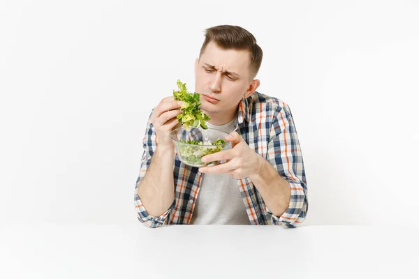 Jonge man zitten aan tafel met groene verse salade met glazen kom geïsoleerd op een witte achtergrond. Goede voeding, vegetarische gerechten, gezonde levensstijl, dieet concept. Gebied met kopie ruimte reclame. — Stockfoto