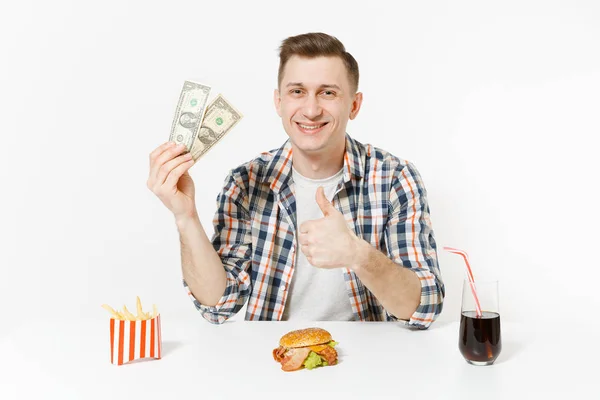 貧しい楽しい 2 つのドル札、ハンバーガー、フライド ポテト、白い背景で隔離のガラスでコーラのテーブルに座っている男の人。適切な栄養やアメリカの古典的なファーストフード。広告コピー スペース付きのエリア. — ストック写真