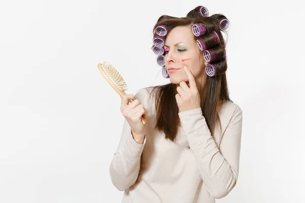 Giovane donna con bigodini utilizzando pettinatura con pettine i capelli isolati su sfondo bianco. Trucco pazzo con set cosmetici decorativi per il viso. Bellezza femminile concetto di stile di vita di moda. Area per copiare spazio . — Foto Stock