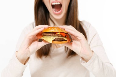 Kırpılan shot genç kadın tutan eller burger yemeye çalışıyor beyaz arka plan üzerinde izole kapatmak. Doğru beslenme veya Amerikan Klasik fast food. Reklam için yer kopyalayın. Reklam alanı.