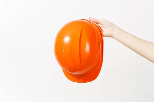 Nær kvinnens horisontale hånd holder den beskyttende oransje hjelmen isolert på hvit bakgrunn. Instrumenter og verktøy til oppussing av leilighetsrom. Reparere hjemmetreff. Annonseområde . – stockfoto