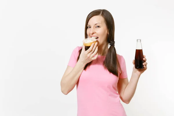 Mooie leuke brunette vrouw holding in handen kleurrijke donuts, cola in glazen fles geïsoleerd op een witte achtergrond. Goede voeding of snoepjes, dessert, fast-food concept. Reclame gebied om te kopiëren van de ruimte — Stockfoto