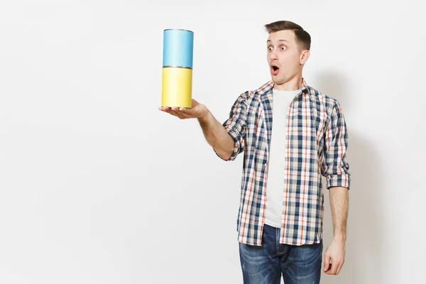 Young shocked man in casual clothes holding empty paint tin cans with copy space isolated on white background. Instruments, accessories, tools for renovation apartment room. Repair home concept. Royalty Free Stock Images