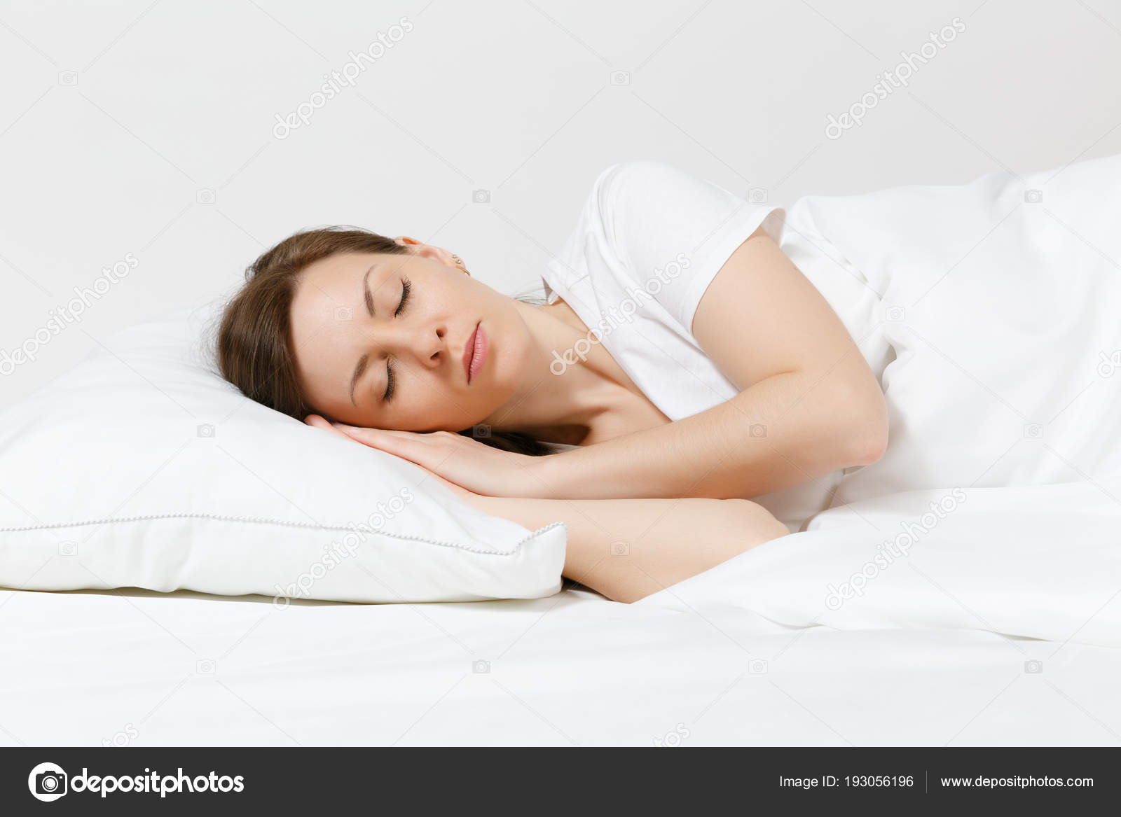 Calm Young Brunette Woman Lying In Bed With White Sheet