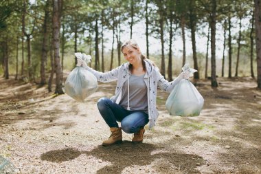 Casual genç gülümseyen kadın temizlik çöp t tutan giysiler