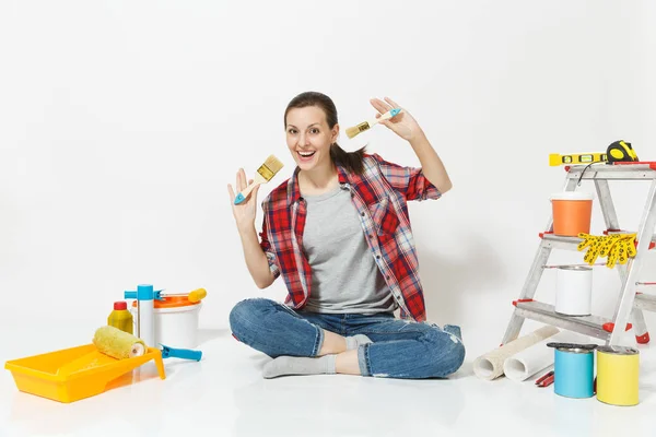Όμορφη γυναίκα με casual ρούχα κάθεται στο πάτωμα με πινέλο, όργανα για δωμάτιο διαμέρισμα ανακαίνιση που απομονώνονται σε λευκό φόντο. Ταπετσαρία αξεσουάρ για την κόλληση εργαλεία ζωγραφικής. Επισκευή concept home — Φωτογραφία Αρχείου