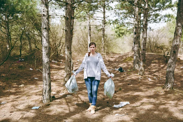 Joven sorprendido mujer preocupada en ropa casual sosteniendo la basura ba — Foto de Stock