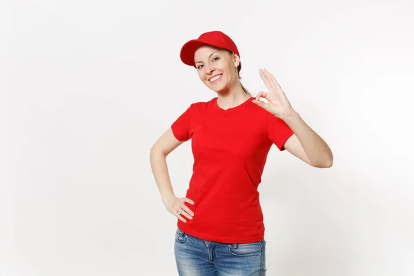 Teslimat samimi kadın beyaz arka plan üzerinde izole kırmızı üniforma. Kapağı, t-shirt, kot çalışan kurye ya da Ok jest gösterilen satıcı olarak profesyonel beyaz kadın. Kopya alanı reklam için