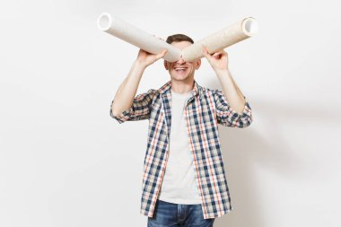 Yakışıklı adam rahat kıyafetler içinde gülümseyen genç duvar kağıdı rulo ile dürbün veya beyaz arka plan üzerinde izole spyglass gibi görünüyor. Yenileme daire oda için aygıtlar. Onarım ev concept.