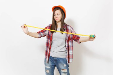 Rahat kıyafetler, koruyucu inşaat kask oyuncak ölçü birimi teyp tutan genç memnun kadın beyaz arka plan üzerinde izole. Aletleri, yenileme daire oda için araçlar. Onarım ev concept.