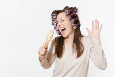 Beyaz arka plan üzerinde izole tarak saç şarkı curlers eğlenceli genç kadınla. Çılgın makyaj set yüz Dekoratif kozmetik ile. Güzellik moda yaşam tarzı kavramı. Uzay kopyalamak için reklam alanı.