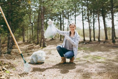 Genç gülümseyen kadın temizlik çöp ve işaret parmağı o işaret