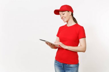 Beyaz arka plan üzerinde izole kırmızı üniformalı teslim kadın. Şu kadın kurye veya satıcısı olarak çalışan, tablet pc bilgisayar boş boş ekran ile tutan kap, t-shirt, kot pantolon. Kopya alanı reklam için