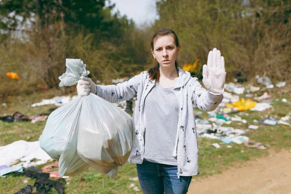Mujer molesta en ropa casual limpieza sosteniendo bolsas de basura y sh — Foto de Stock