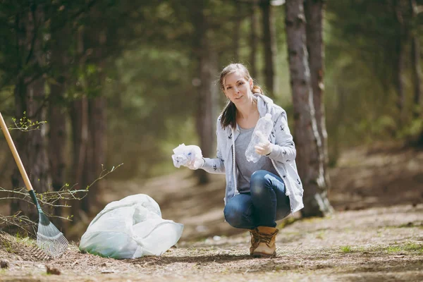 Mujer joven con ropa casual, guantes limpiando basura en los tras — Foto de Stock