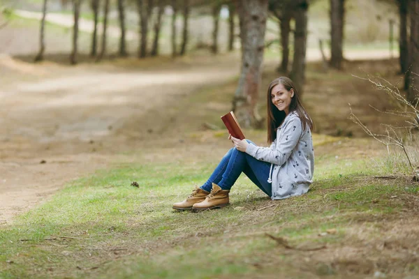 Joven sonriente hermosa mujer en ropa casual sentado en groun — Foto de Stock