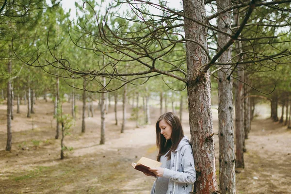 Joven mujer hermosa calma en ropa casual apoyada en stu árbol — Foto de Stock