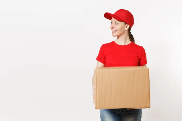 分娩微笑的女人穿着红色制服, 被隔离在白色背景上。女性在帽子, t恤, 牛仔裤工作作为信使或经销商持有纸板箱。接收包。复制广告空间. — 图库照片