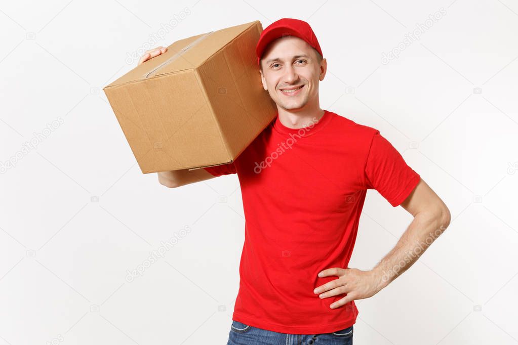 Delivery young man in red uniform isolated on white background. Male in cap, t-shirt, jeans working as courier or dealer holding empty cardboard box. Receiving package. Copy space for advertisement.