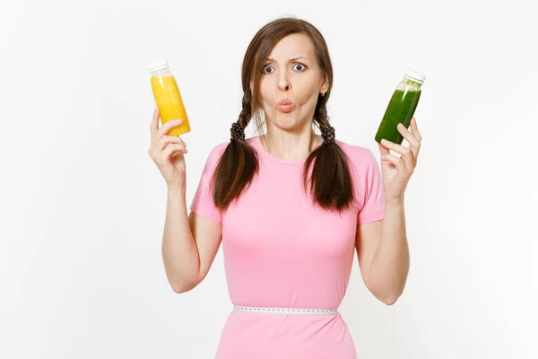 Mujer triste sostiene verde, amarilla desintoxicación batidos en botellas, cinta métrica en la cintura aislado sobre fondo blanco. Nutrición adecuada, bebida vegetariana, estilo de vida saludable, concepto de dieta. Copiar espacio, flack . — Foto de Stock