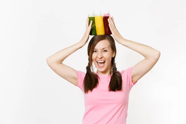 Mujer divertida sostiene fila de licuados desintoxicantes verdes, rojos y amarillos en botellas aisladas sobre fondo blanco. Nutrición adecuada, bebida vegetariana, estilo de vida saludable, concepto de dieta. Copiar espacio para publicidad . — Foto de Stock